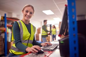 apprentice working a computer in a warehouse